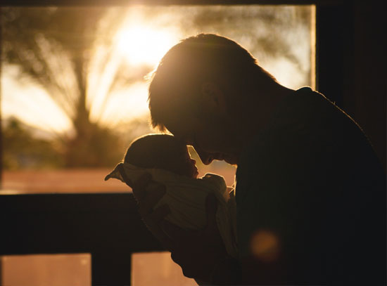 Silhouette of man holding baby